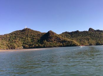 View of calm blue sea against mountain range