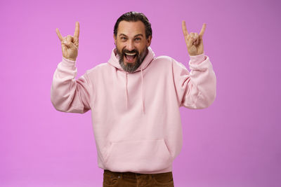 Portrait of man standing against colored background