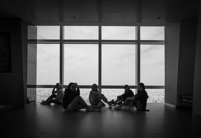 People sitting on floor by window