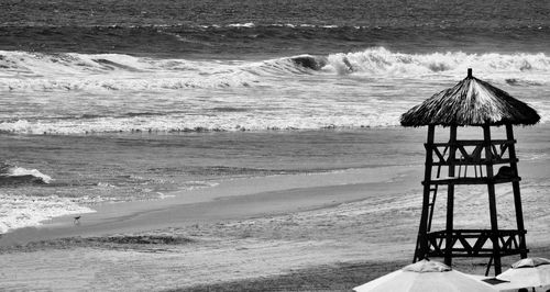 Lifeguard hut on beach against sky