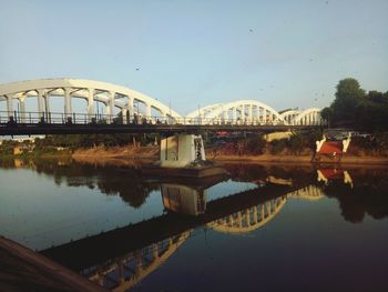 Arch bridge over river against sky