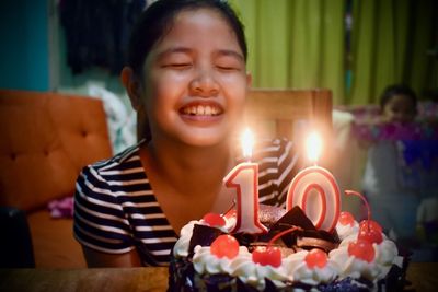 Close-up of girl with eyes closed by birthday cake