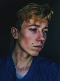 Close-up of young man against black background