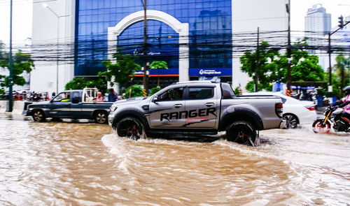 Car on street by buildings in city