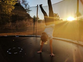 Portrait of a girl making a handstand on trampoline