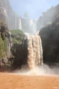 Scenic view of waterfall against sky