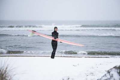 Woman going surfing during winter snow