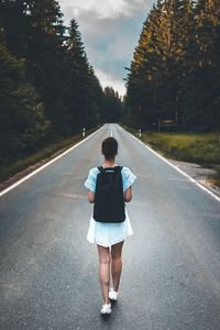 Rear view of woman walking on road