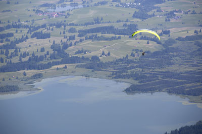 Paraglider flying over bavarian lake forggensee