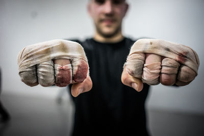 Close-up of male athlete showing fists with hand wrap