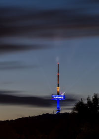 View of illuminated factory against sky at dusk