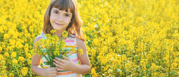 Smiling girl holding bunch of flowers