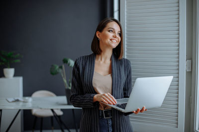 Young woman working on laptop in modern office