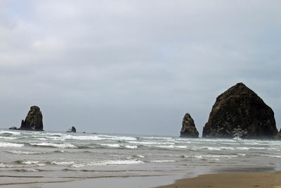 Rock formation on beach against sky