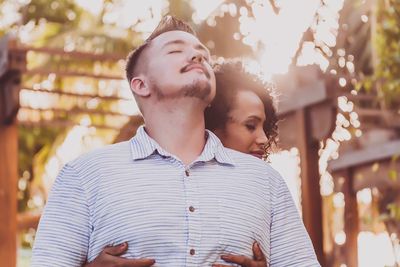 Low angle view of woman embracing man at park