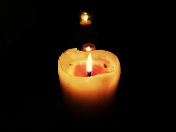 Close-up of lit candle against black background
