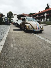 Cars on road in city against sky