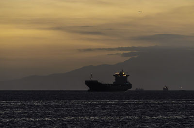 Silhouette ship sailing on sea against sky during sunset