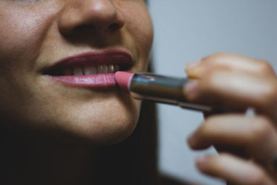 Close-up of woman applying lipstick