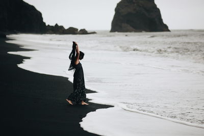 Full length of woman standing on cliff