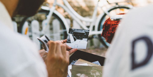 Midsection of man looking while holding photograph