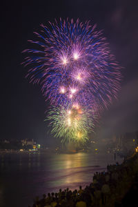 Firework display over river at night