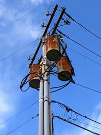 Low angle view of electricity pylon against clear sky