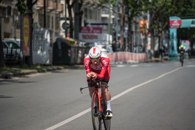 Man riding bicycle on road in city