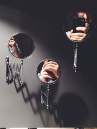 Reflection of man on mirror while photographing using mobile phone