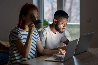 Young woman using laptop at table