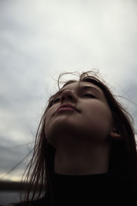 Portrait of young woman against sky