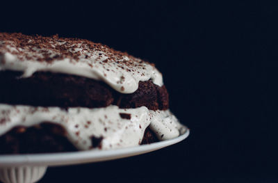 Close-up of chocolate cake on cakestand against black background