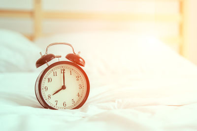 Close-up of clock on bed at home