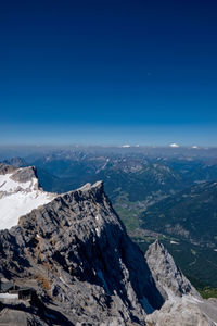 Scenic view of snowcapped mountains against blue sky