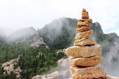 Stack of rocks on mountain against sky