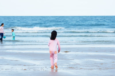 Rear view of child with family on beach