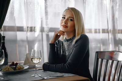 Portrait of young woman sitting at table