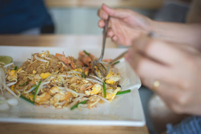 Cropped image of woman having noodle puff