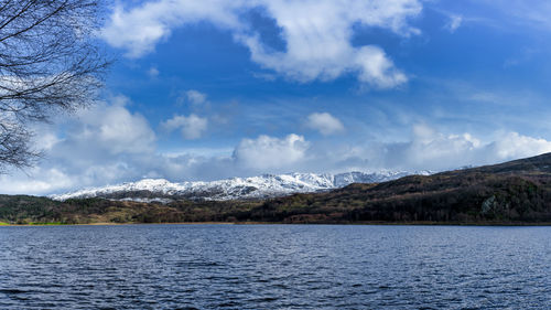 Scenic view of sea by mountains against sky