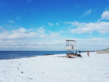 Lifeguard hut on beach against sky