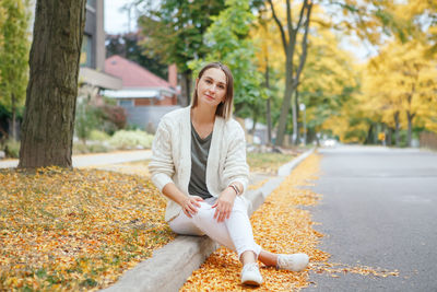 Portrait of smiling young woman with leaves during autumn