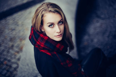 Portrait of young woman with scarf looking up at camera