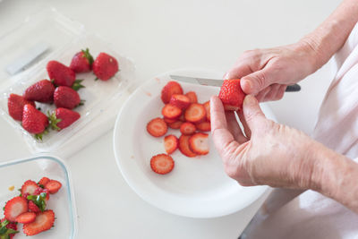 High angle view of hand holding strawberries