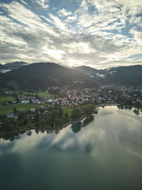 High angle view of townscape by lake against sky during sunset