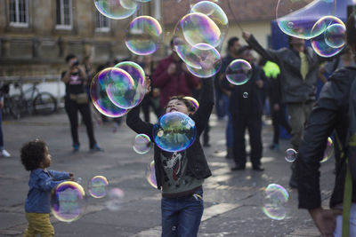 People with bubbles on street in city