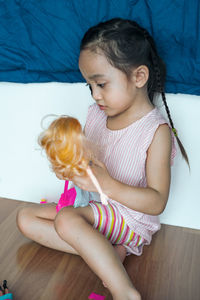 Young asian kid at home playing fashion doll. child in kindergarten. kid in nursery school.