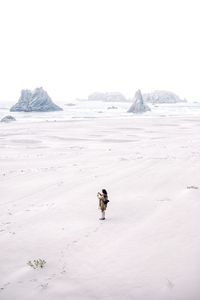 Person on snowcapped mountain against sky