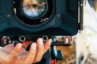 Cropped hand of man holding camera