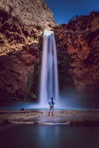 Woman standing in front of waterfall