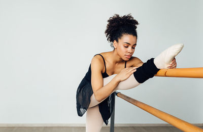 Young woman looking away while exercising in gym